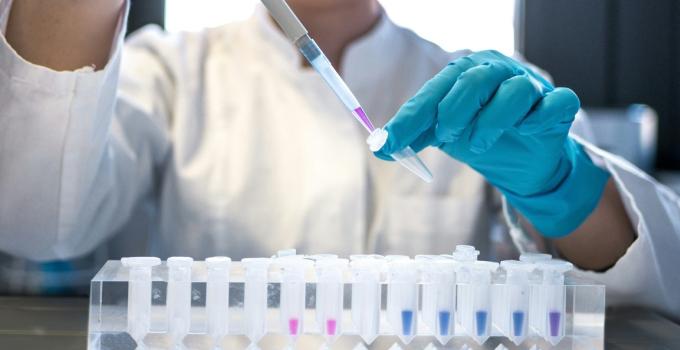 An image of a person adding liquid to a vial
